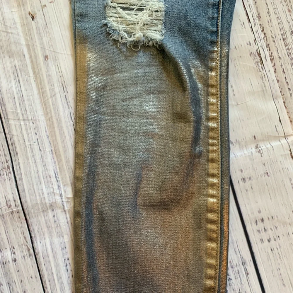 Level 99 jeans. Gold/silver design on bottom. Mid rise. Size 27.